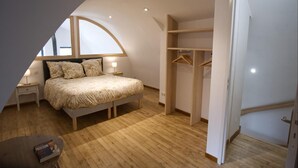 A bedroom with a bed, bedside tables, a wardrobe, and a small table with a book.