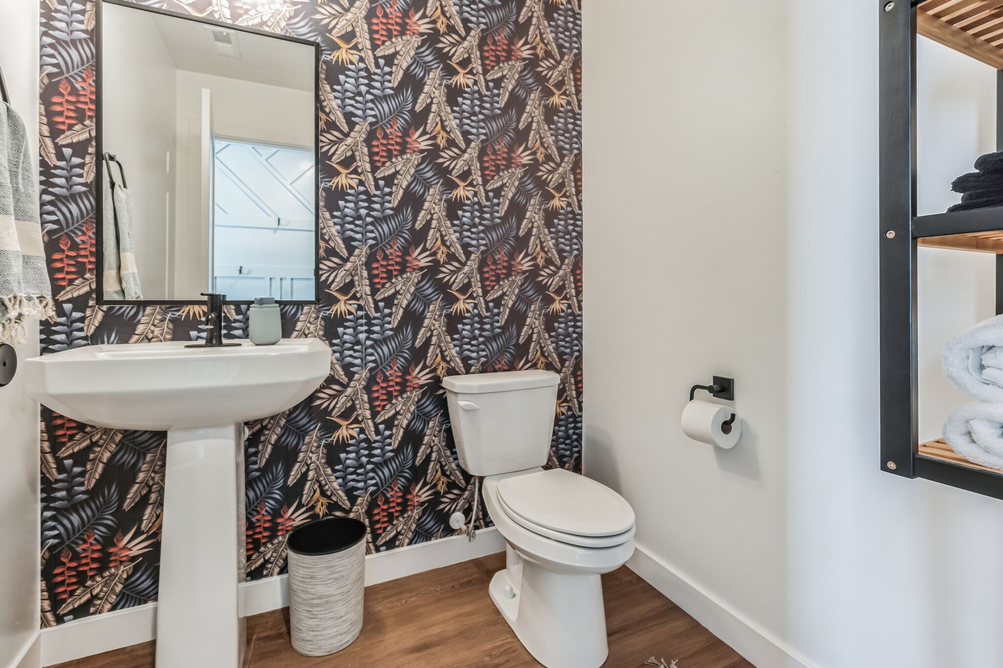 A bathroom with a toilet, sink, and mirror.