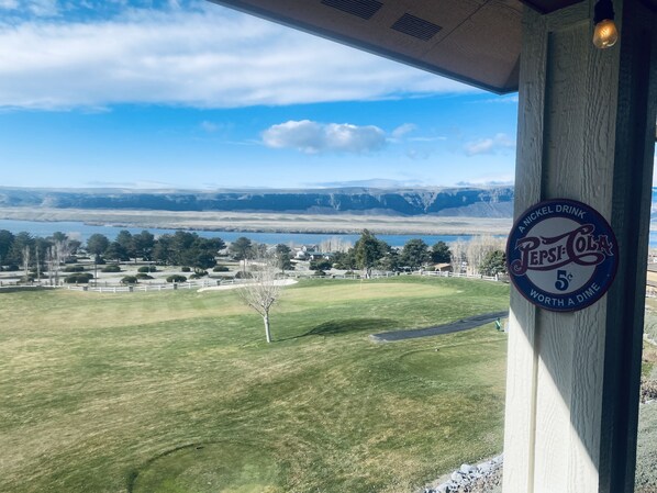 Vista de un campo de golf con un letrero de Pepsi-Cola en un edificio.