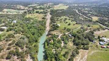 A rural landscape with a river, scattered buildings, and green fields.