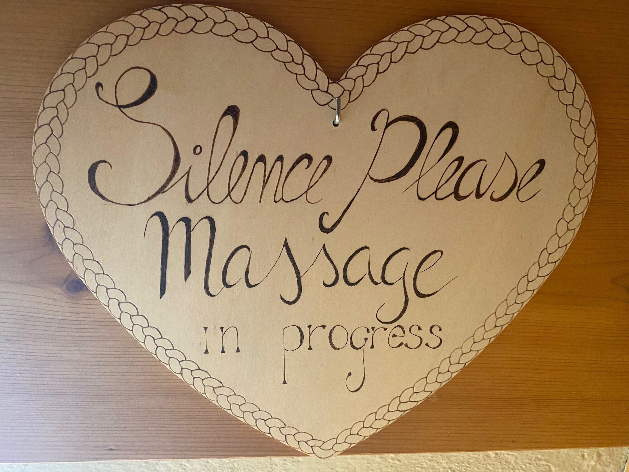 Ein herzförmiges Schild mit dem Aufdruck: „Ruhe bitte, Massage im Gange.