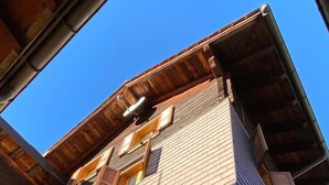 A multi-story building with a brick facade, wooden beams, and a sloped roof. - Chalet del Sole  (Quinto)