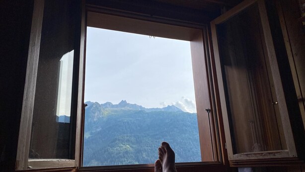 A room with a large window offering a mountain view. - Chalet del Sole  (Quinto)