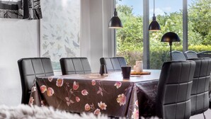 A dining area with a floral tablecloth, black chairs, and pendant lights. - Cozy home in Sydals with WiFi (Sydals)