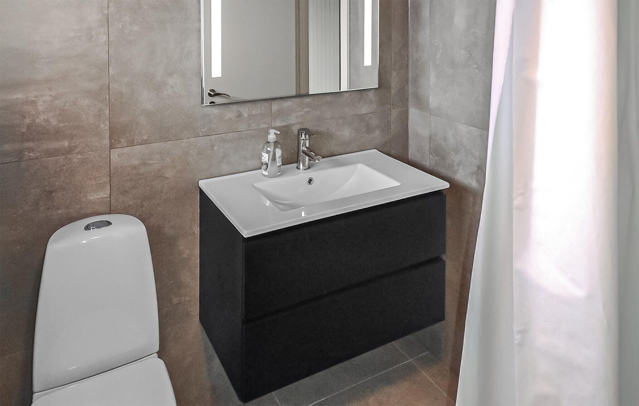 Une salle de bain avec un lavabo blanc, un meuble-lavabo foncé et un miroir au-dessus du lavabo.