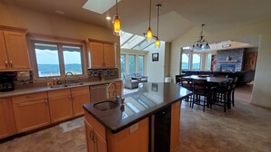 A modern kitchen with wooden cabinets, a central island, and pendant lighting.