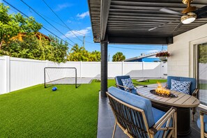 Un patio con mesa y sillas, un brasero y una portería de fútbol.
