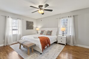 A bedroom with a bed, bedside tables, a ceiling fan, and a window with curtains. - Marietta GEM 4-bedroom/3 bed - pet friendly -flexible monthly stays  (Marietta)