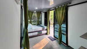 A bedroom with a bed, curtains, and a view of the outdoors. - Quaint Villa in Villavicencio. Connect with nature without compromising comfort (Villavicencio)