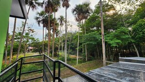 A staircase leading to a covered outdoor area with a view of tall trees and a grassy landscape. - Quaint Villa in Villavicencio. Connect with nature without compromising comfort (Villavicencio)