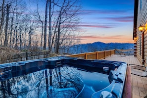 A hot tub on a wooden deck with a view of trees and hills. - Mountain Retreat, Balcony, Hot Tub, and Grill! (Waynesville)