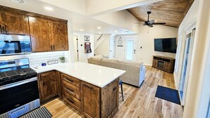 Una cocina moderna con armarios de madera, una isla grande y una estufa empotrada.