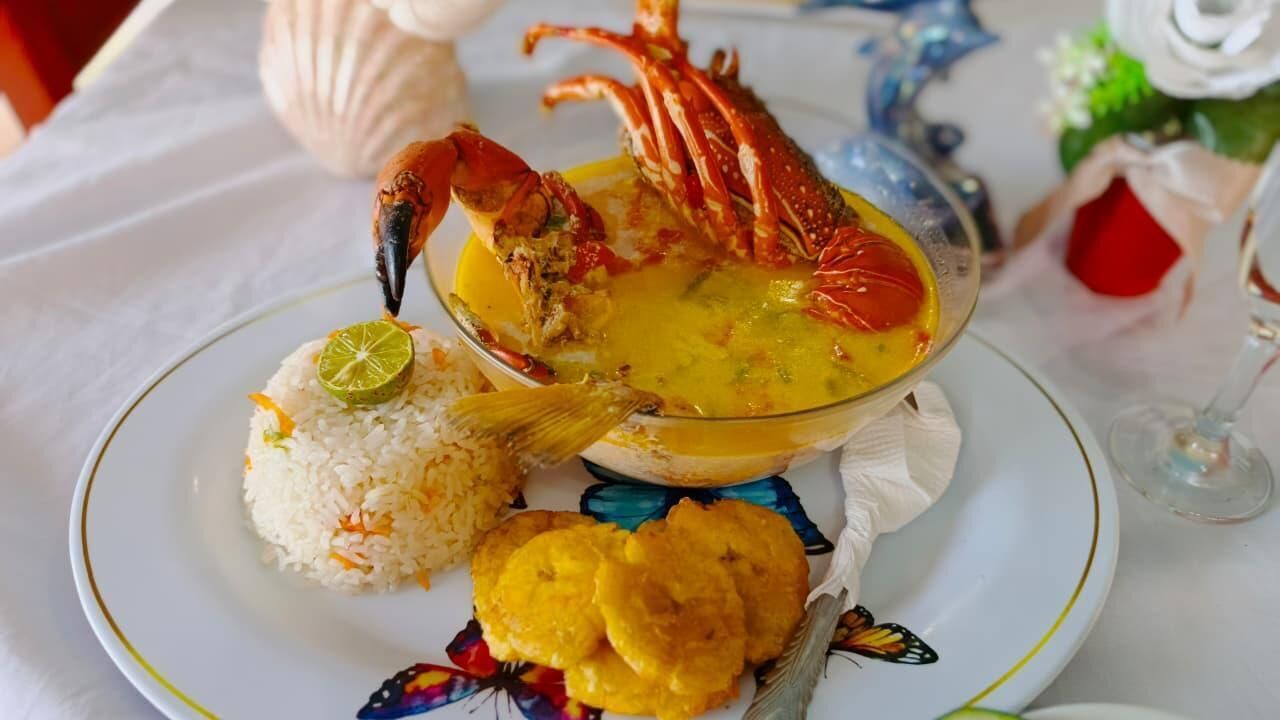 Een bord met kreeft, rijst en plantains.