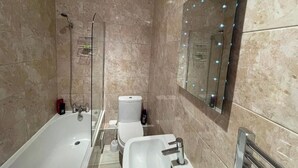 Un baño con bañera, lavabo, inodoro y zona de ducha.