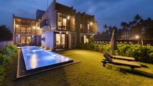 A modern house with a swimming pool, outdoor seating, and a well-maintained garden. - Inidi Leisure Luxury Villas (Wadduwa)