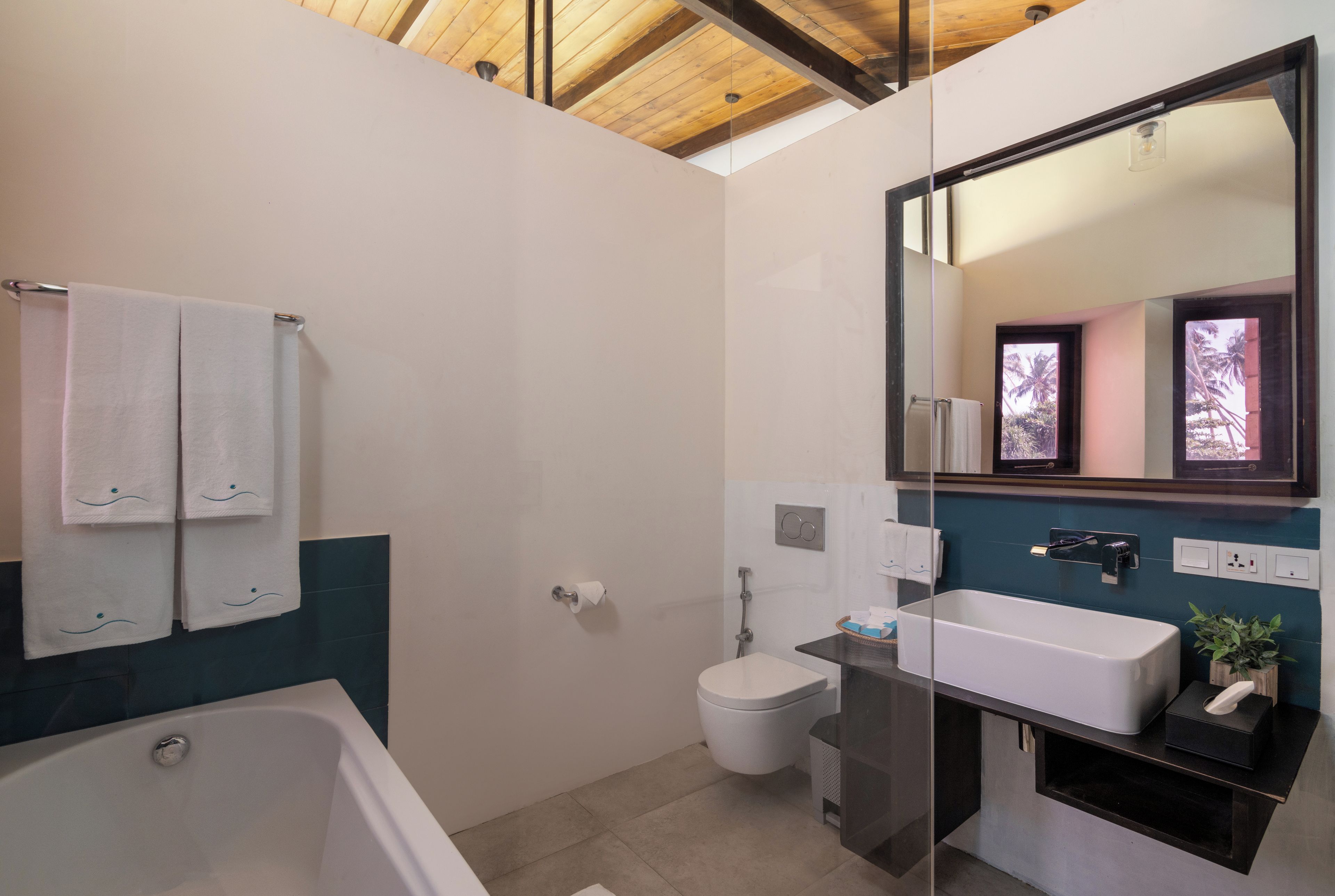 A modern bathroom with a bathtub, a toilet, and a shower.
