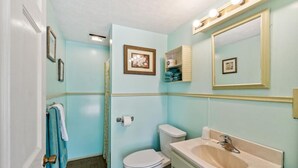 A bathroom with a toilet, sink, and shower area. - Sunset Acres Motel - Number 8 (Hudson)