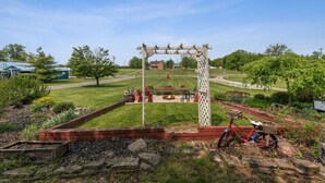 Un jardín con un porche de madera, una chimenea y una bicicleta.