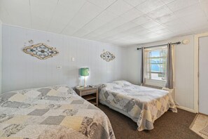 Ein Zimmer mit zwei Betten, einem Vorhangfenster und Wanddekoration.