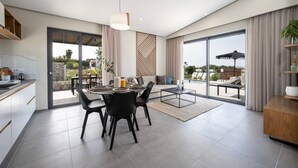 Una sala de estar moderna con comedor, puertas correderas de vidrio que dan a un patio exterior y vistas al paisaje.