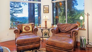 A room with two leather armchairs, a table with a lamp, and a bookshelf. - Palazzo Marzino ~ An Italian Inspired Villa ~ 3 Bed ~ 3 Bath ~ Pool ~ Hot Tub ~ (Guerneville)
