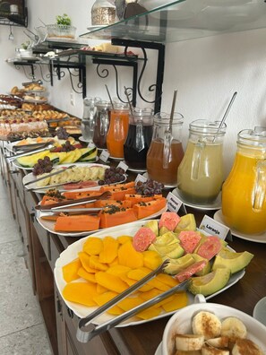 Un buffet con frutta, verdura e bevande assortite.
