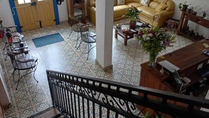 A spacious living area with a yellow sofa, a coffee table, and a bookshelf. - Pousada Sinhá Moça Campos Ltda (São João del Rei)