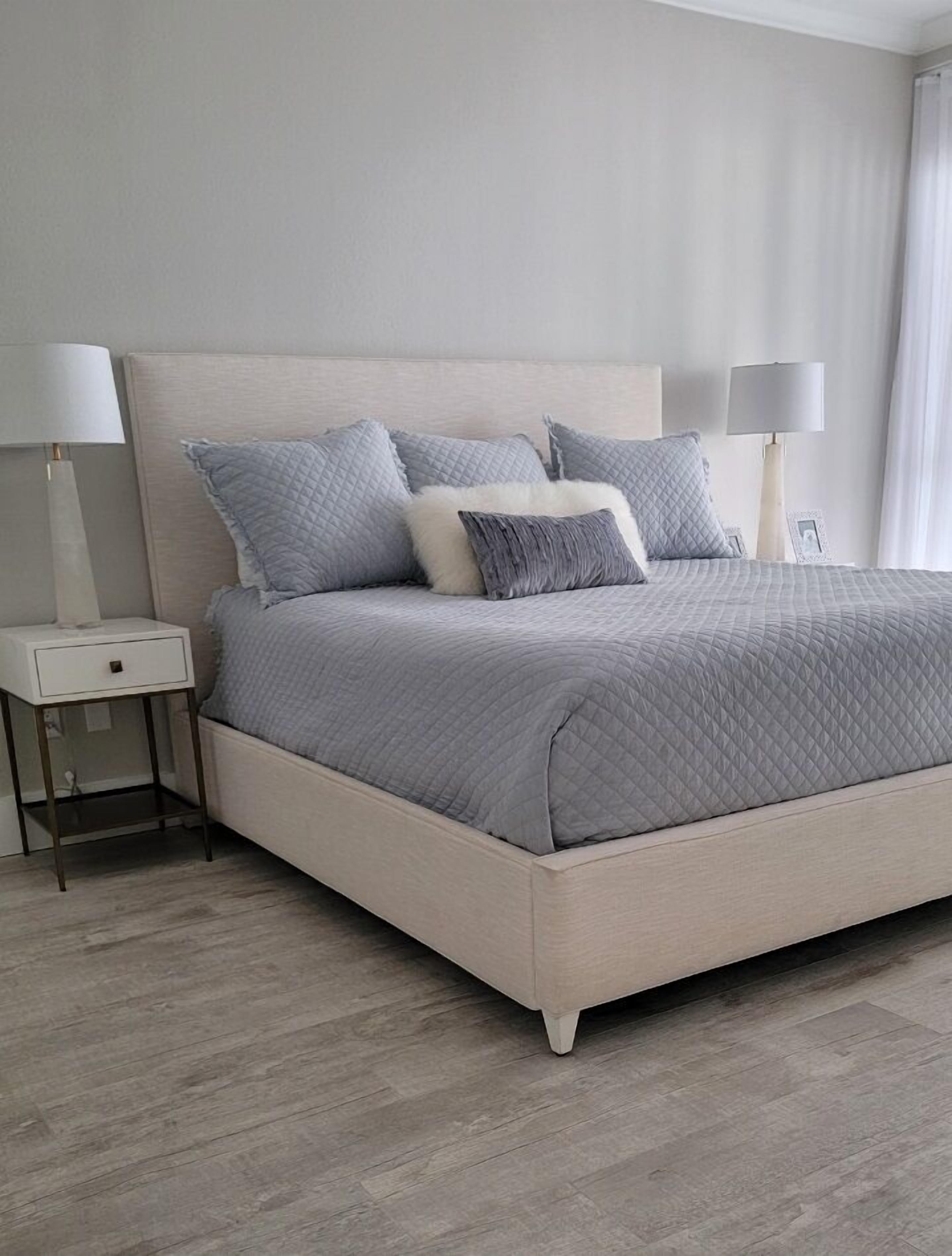 Un dormitorio moderno con una cama grande, dos mesitas de noche y una mesilla.