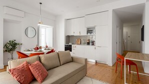 Un espace de vie moderne comprenant un canapé, une table à manger et un coin cuisine.