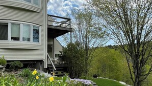 Et toetagers hus med balkon og en stensti, der fører til indgangen.