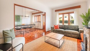 Amplia sala de estar con sofá, mesa de centro y sillas de comedor.