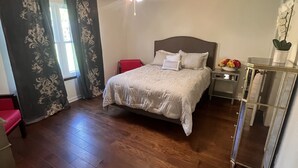 A bedroom with a bed, a nightstand, a dresser, a ceiling fan, and a window with curtains. - Excellent three bedroom two bath condo close to KU campus  (Lawrence)