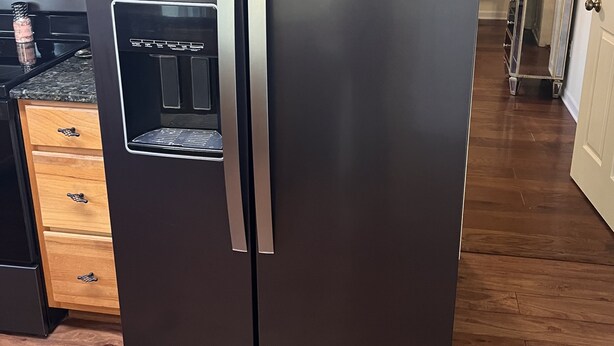 A modern kitchen with a stainless steel refrigerator, wooden cabinets, and a built-in oven. - Excellent three bedroom two bath condo close to KU campus  (Lawrence)
