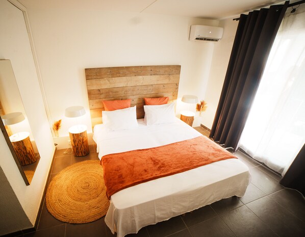 Relax in comfort with a large bed, bedside lamps, and a cozy rug.