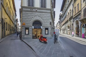 Une rue où se trouve une boutique appelée « FONT » et un scooter garé.