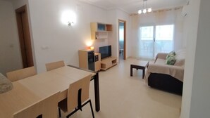 A modern living room with a TV, wooden furniture, and a sofa. - ACV - Vistamar Iii-1ª Linea Planta 2 Norte 2 (OROPESA)
