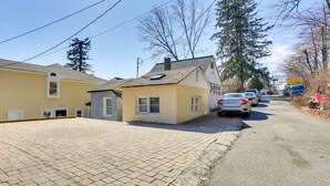 A residential street with houses, a paved driveway, and parked cars. - Greenwood Lake Cottage w/ Shared Dock & Hot Tub! (Hewitt)