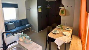 A compact living space with a kitchenette, dining area, and seating area.