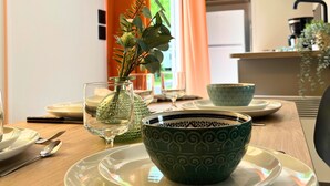 Una mesa de comedor dispuesta con platos, tazones y cubiertos.
