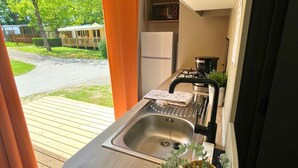 Cocina compacta con lavamanos, estufa y microondas.