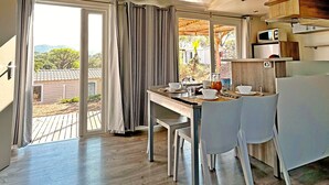 Una cocina moderna con comedor, ventanas amplias y vistas al exterior.