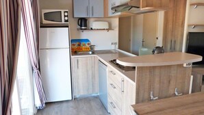 A compact kitchen with a microwave, toaster, and a small sink.