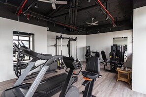 A gym with treadmills, weight machines, and a mirror. - (1006) Apartamento com 2 Suítes e Vista para o Cristo (Rio de Janeiro)