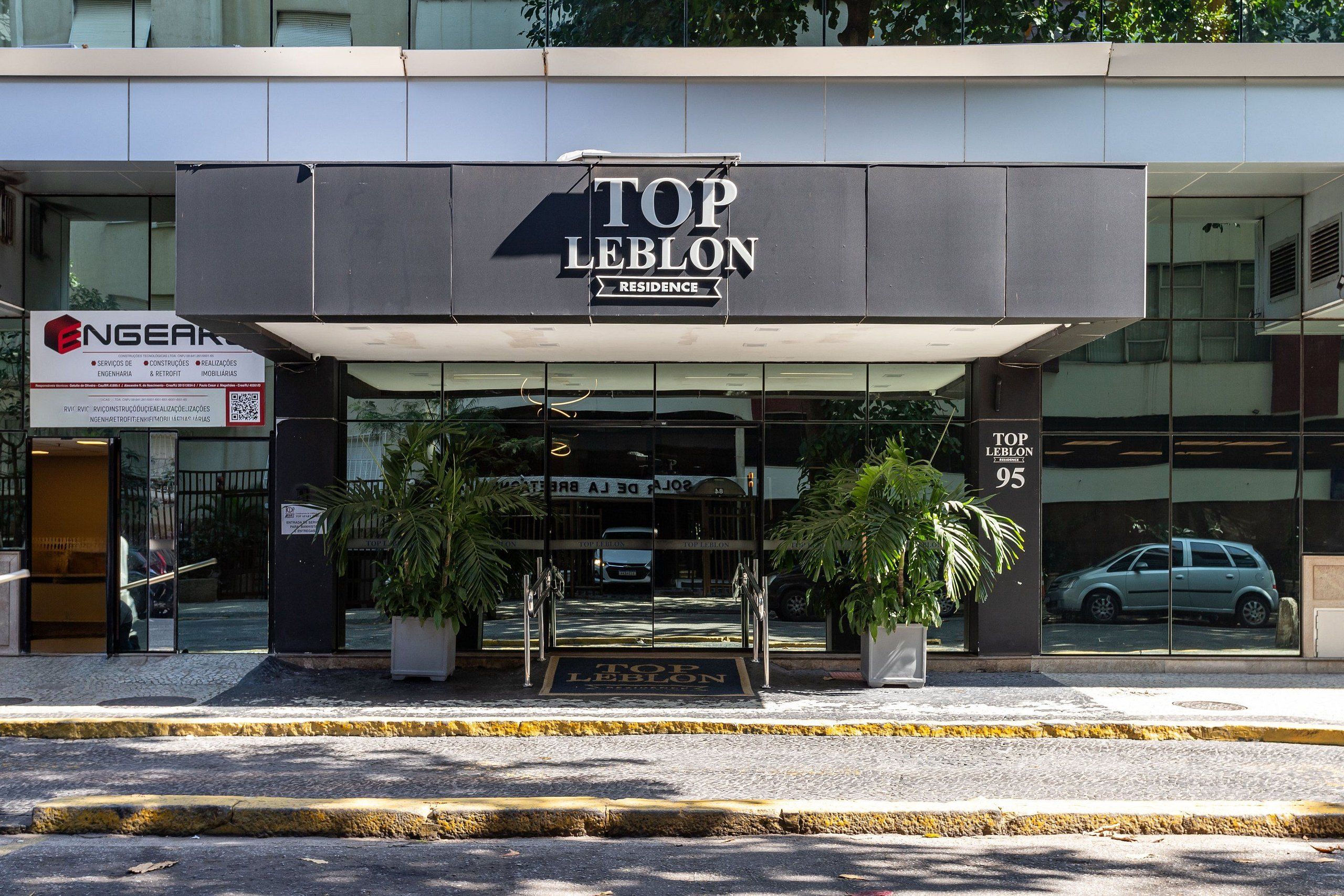 Um edifício com uma placa que diz 'TOP LEBLON RESIDENCE'.