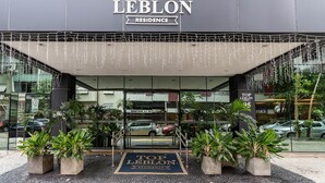 The entrance of Top Leblon Residence with a clear view of the entrance, potted plants, and the building's signage. - (1006) Apartamento com 2 Suítes e Vista para o Cristo (Rio de Janeiro)