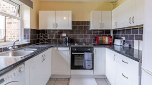 A modern kitchen with white cabinets, a granite countertop, a built-in oven, and a microwave. - 1bed-sleeps3 Parking-nearcitycentre-jlr-nec (Birmingham)