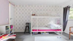 A bunk bed room with a wardrobe, a chair, and a window with curtains. - 2 bedroom amazing home in Kolind (Kolind)