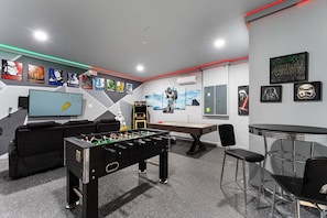 Quarto com mesa de futebol, área de bar e decoração temática de Star Wars.