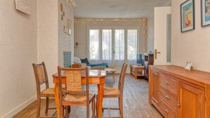 Ein Essbereich mit Holmöbeln, einem Schrank und einem Fenster mit Vorhängen.