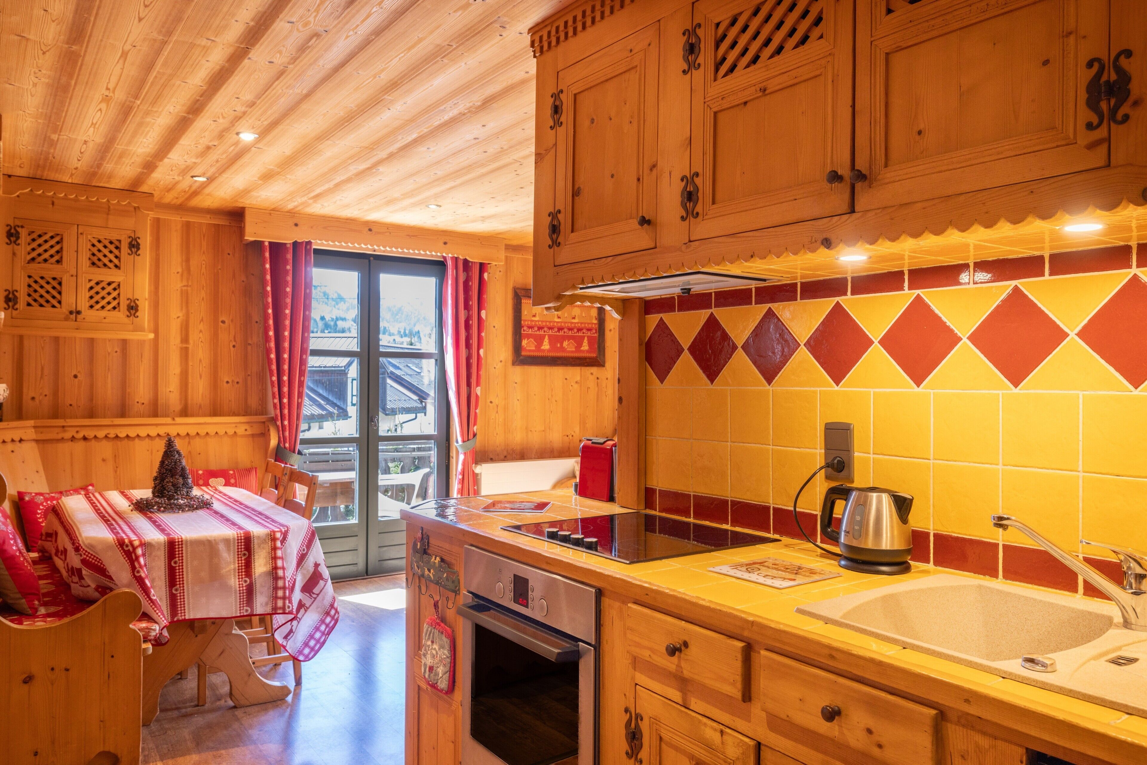 A wooden interior with a kitchen area featuring a stove, oven, sink, and cabinets.